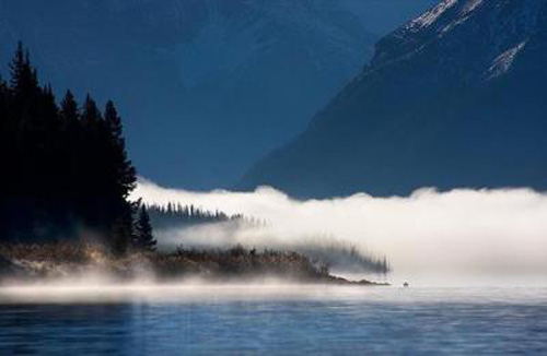 Vào lúc bình minh, một làn sương mù dày đặc bao phủ mặt hồ phẳng lặng.